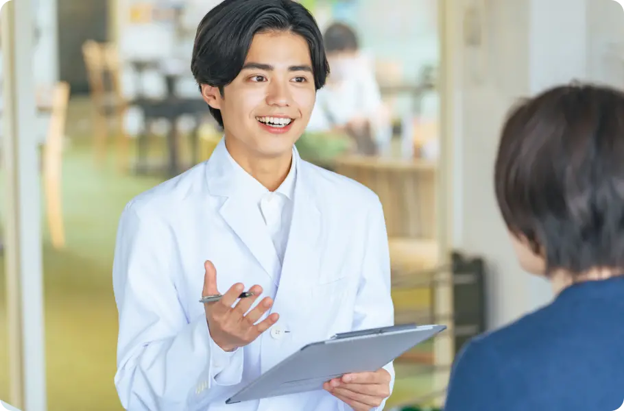 男性薬剤師が笑顔で患者に資料を見せながら説明している様子