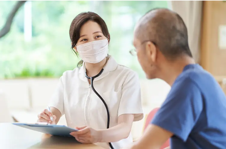 医療従事者が男性患者と書類を使って相談している様子